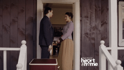 A Man And Woman Are Standing In Front Of A Door That Says Super Channel Heart And Home GIF