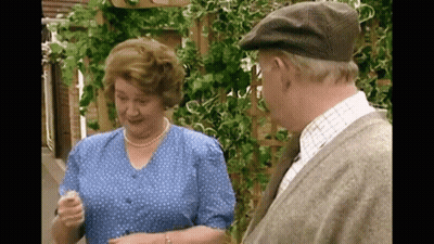 A Man And Woman Are Standing Next To Each Other And Talking GIF
