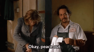 A Man And Woman Are Standing Next To Each Other And The Man Is Holding A Piece Of Paper That Says Okay Peace Out GIF