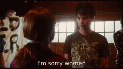 A Man And Woman Are Standing Next To Each Other And The Woman Is Saying I 'M Sorry Women . GIF