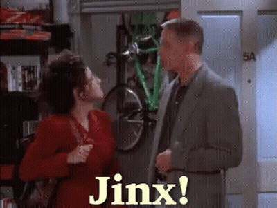 A Man And Woman Are Standing Next To Each Other And The Woman Is Saying Jinx GIF