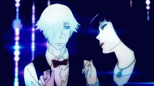 A Man And Woman Are Standing Next To Each Other In A Dark Room GIF