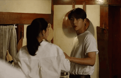 A Man And Woman Are Standing Next To Each Other In A Kitchen . GIF