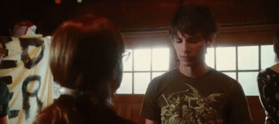 A Man And Woman Are Standing Next To Each Other In A Room . GIF