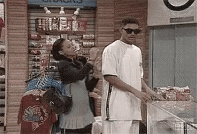 A Man And Woman Are Standing Next To Each Other In A Store . GIF