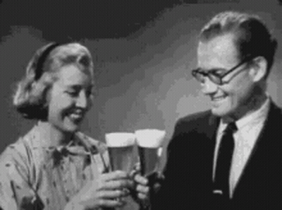 A Man And Woman Are Toasting With Beer Glasses . GIF