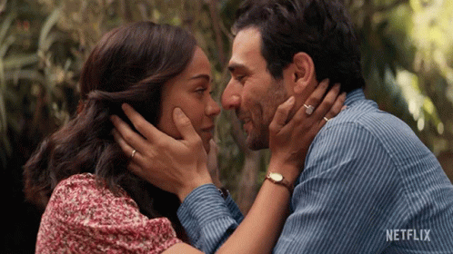 A Man And Woman Are Touching Their Foreheads With A Netflix Logo In The Background GIF
