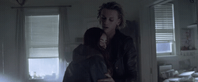 A Man And Woman Hugging In A Dark Room GIF