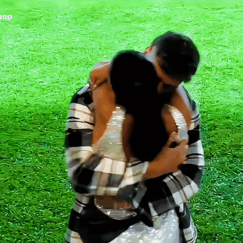 A Man And Woman Hugging In A Field With The Word Ano On The Bottom Right GIF