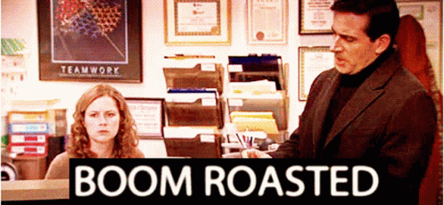 A Man And Woman In An Office With A Sign That Says Boom Roasted On It GIF