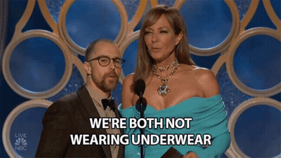 A Man And Woman On A Stage With The Words We 'Re Both Not Wearing Underwear Behind Them GIF