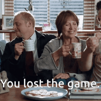 A Man And Woman Sitting At A Table With The Words You Lost The Game Written Below Them GIF