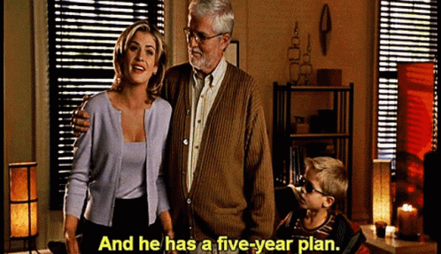A Man And Woman Standing Next To A Boy With The Words And He Has A Five Year Plan GIF