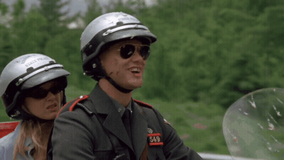 A Man And Woman Wearing State Police Helmets GIF