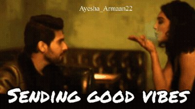 A Man Blowing A Kiss To A Woman With The Words Sending Good Vibes Below Him GIF
