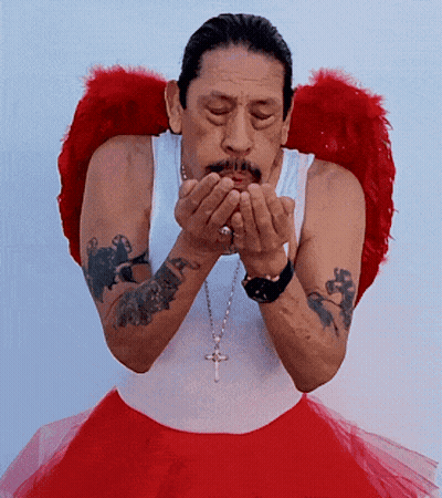 A Man Blowing A Kiss Wearing Red Angel Wings And A Red Tutu GIF