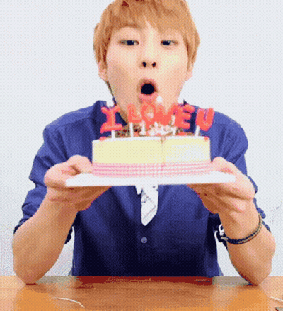A Man Blows Out Candles On A Birthday Cake That Says I Love You GIF