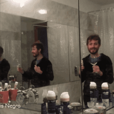 A Man Brushing His Teeth In Front Of A Mirror With The Word Negra On The Bottom Left GIF