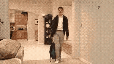 A Man Carrying A Backpack Is Walking Through A Living Room GIF
