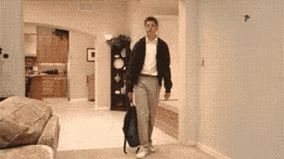A Man Carrying A Backpack Is Walking Through A Living Room GIF