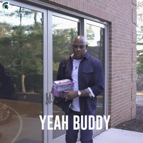 A Man Carrying A Box With The Word Yeah Buddy On The Bottom GIF