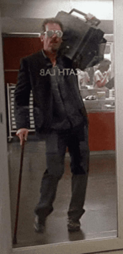 A Man Carrying A Suitcase Has A Shirt That Says 8Ajhta3 GIF