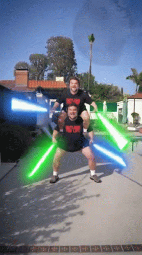 A Man Carrying Another Man On His Shoulders Is Wearing A Shirt That Says Heavy Metal GIF