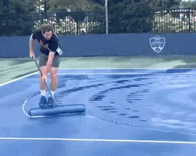 A Man Cleaning A Tennis Court With A Roller GIF
