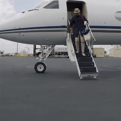 A Man Climbs The Stairs Of An Airplane That Says Atl GIF