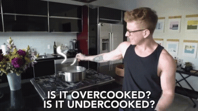 A Man Cooking In A Kitchen With The Words " Is It Overcooked Is It Undercooked " Above Him GIF