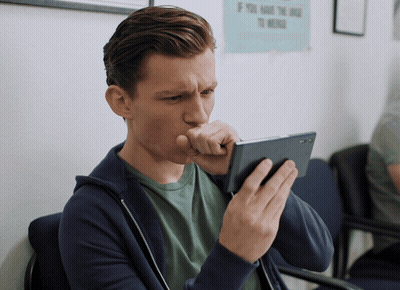 A Man Coughing While Looking At His Cell Phone In Front Of A Sign That Says If You Have The Drug To Medicate GIF