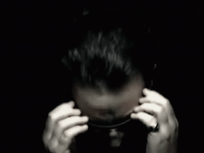 A Man Covering His Ears With His Hands In A Black And White Photo . GIF