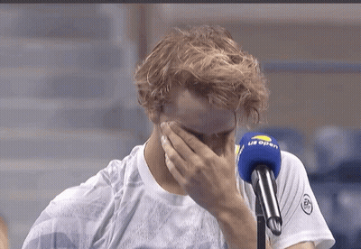 A Man Covering His Face In Front Of A Microphone That Says ' Us Open ' On It GIF