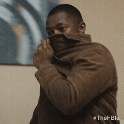 A Man Covering His Face With A Brown Jacket With The Hashtag #Thefbis GIF