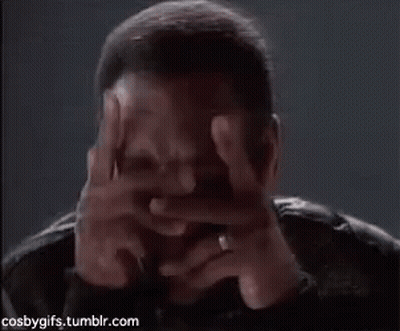 A Man Covering His Face With His Hands In A Dark Room . GIF