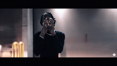 A Man Covering His Face With His Hands In Front Of A Wall GIF