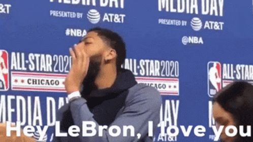 A Man Covering His Mouth While Standing In Front Of A Sign That Says Media Day GIF