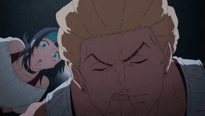 A Man Covering His Mouth With His Finger While A Woman Looks On Behind Him GIF