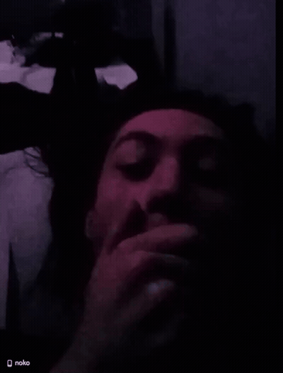 A Man Covering His Mouth With His Hand In A Dark Room With A Nokia Logo On The Bottom Right GIF