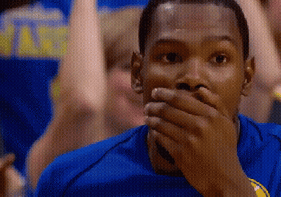 A Man Covering His Mouth With His Hand While Wearing A Golden State Warriors Jersey GIF