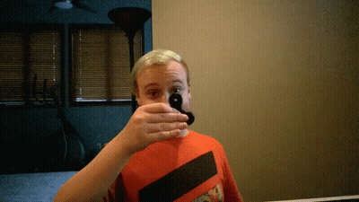 A Man Covering His Mouth With His Hand While Wearing A Red Shirt GIF