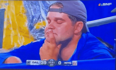A Man Covering His Nose With His Finger While Watching A Game GIF