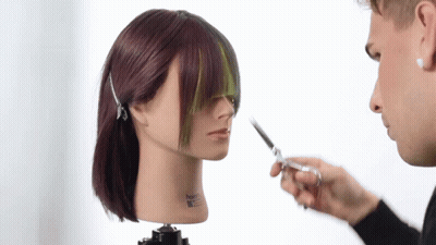 A Man Cutting A Mannequin 'S Hair With A Pair Of Scissors GIF
