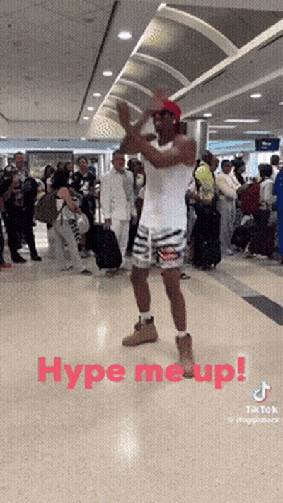 A Man Dancing In An Airport With The Words Hype Me Up GIF