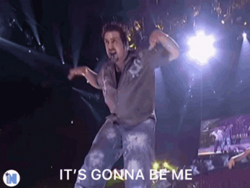 A Man Dancing On Stage With The Words It 'S Gonna Be Me Above Him GIF