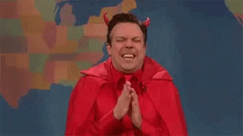 A Man Dressed As A Devil With Horns Is Praying With His Hands Folded . GIF