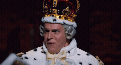 A Man Dressed As A King With A Crown On Top Of His Head GIF