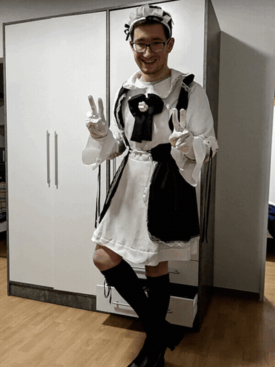 A Man Dressed As A Maid Giving A Peace Sign GIF