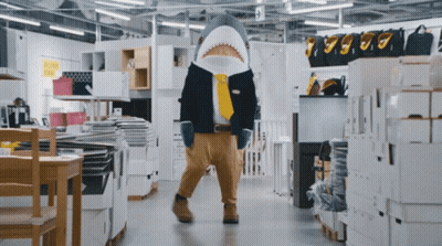 A Man Dressed As A Shark In A Store GIF
