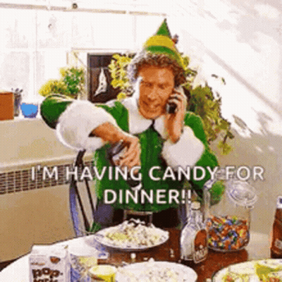 A Man Dressed As An Elf Is Talking On A Cell Phone While Sitting At A Table . GIF